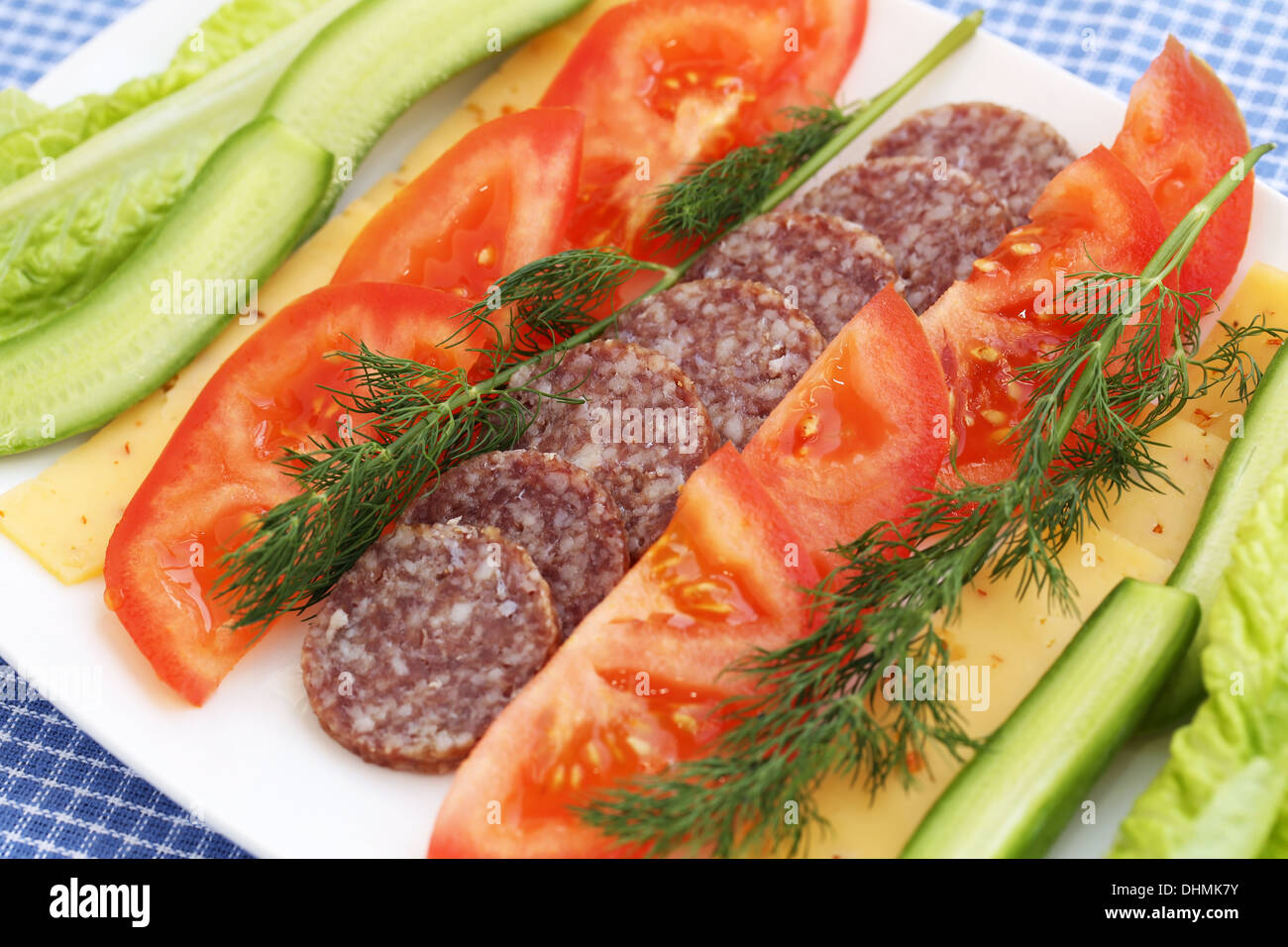 Salami, Käse und frisches Gemüse auf Platte. Stockfoto