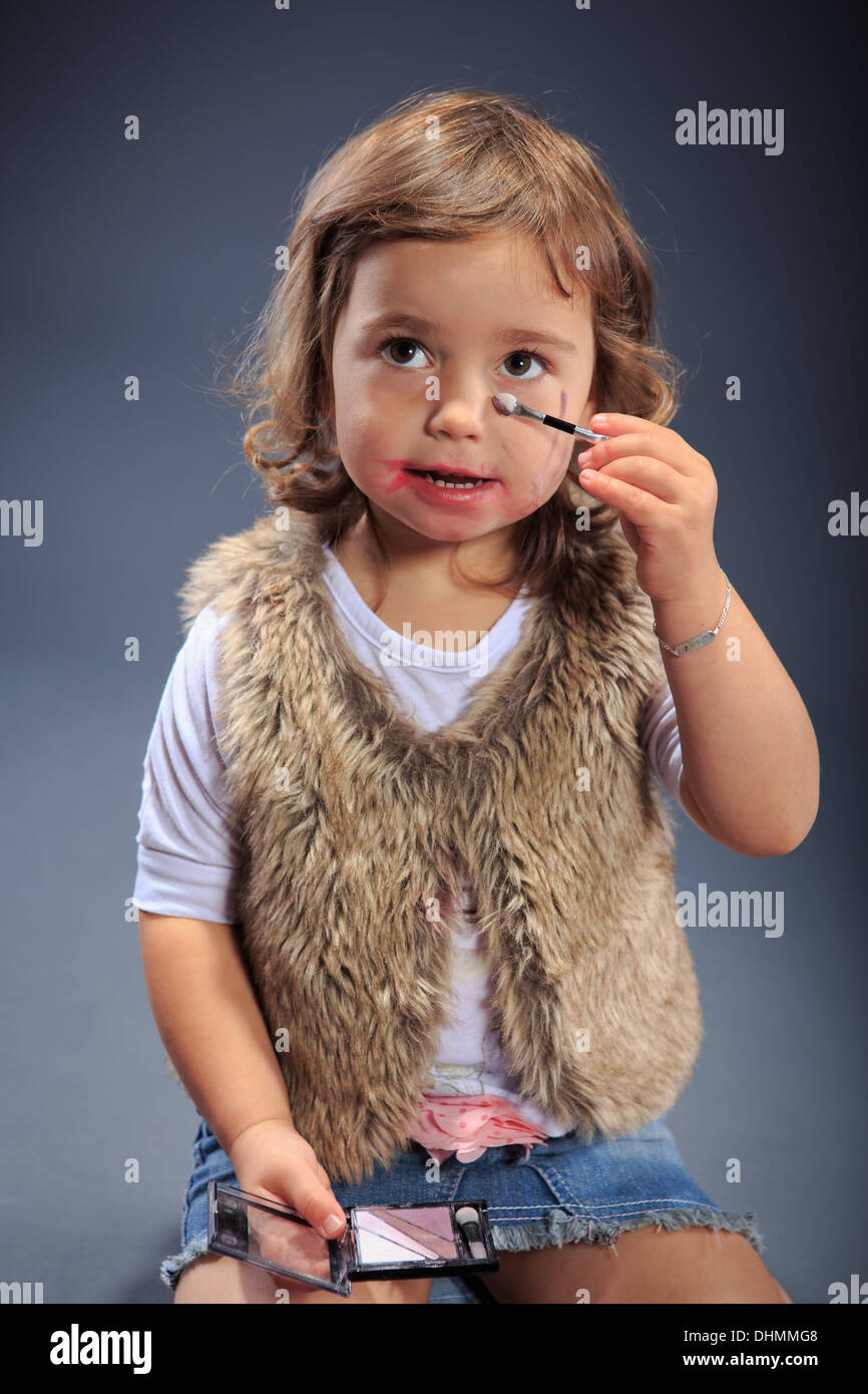 Studioaufnahme von einem kleinen Mädchen, die sich selbst schminken Stockfoto