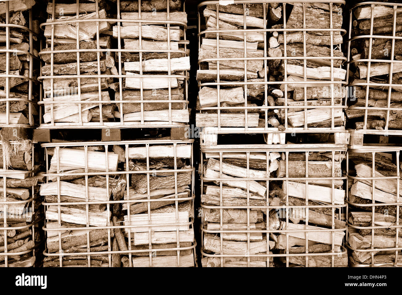 Brennholz gestapelt in Gitter-Boxen sepia Stockfoto
