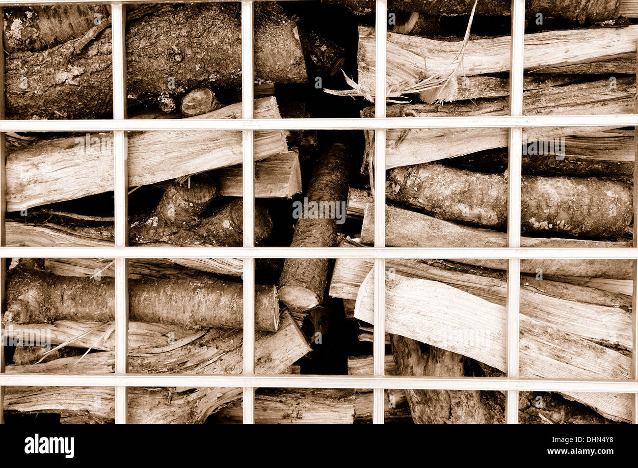 Brennholz hinter Bars sepia Stockfoto