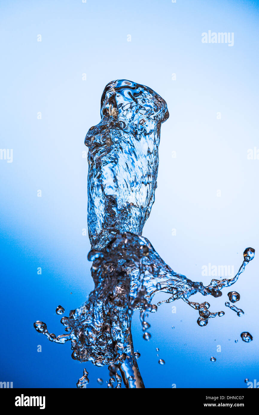 sauberes Wasser Spritzen auf blauem Hintergrund. Wasser ist eine notwendige Bedingung für die Existenz des Lebens auf der Erde Stockfoto
