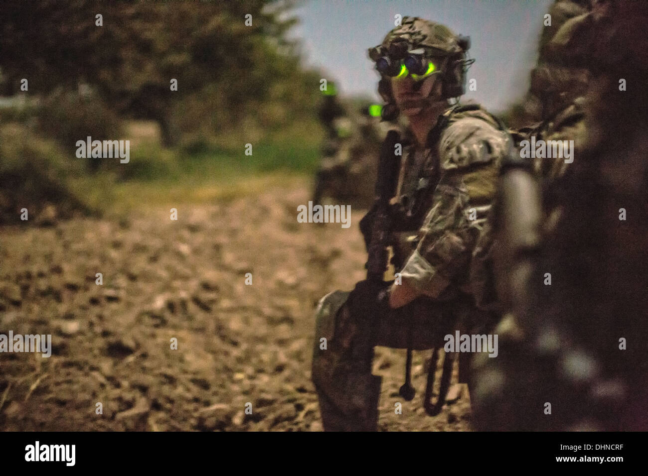 US Army Soldat trägt Nachtsicht Brille hält Uhr während einer nächtlichen Suchaktion 14. Oktober 2013 in der Provinz Helmand, Afghanistan, 14. Oktober 2013. Afghanische und Koalition Truppen verhaftet ein Taliban improvisierten Sprengkörpern Zelle Führer während des Betriebs. Stockfoto