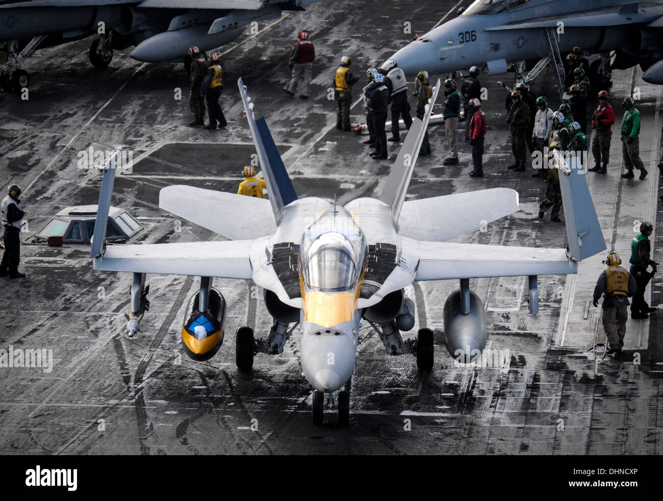 Ein Flugzeug der US Navy F/A - 18C Hornet taxis auf dem Flugdeck des Flugzeugträgers USS Nimitz im Flugbetrieb 6. November 2013 in das Mittelmeer. Stockfoto