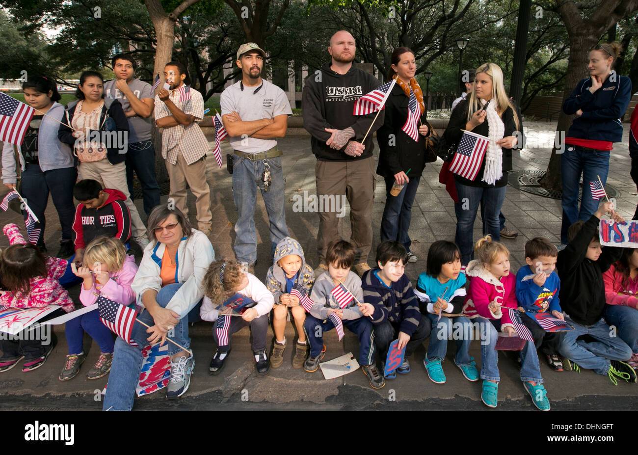 Drängen sich mit Kindern und Erwachsenen halten Flaggen, Hände schütteln und jubeln für Kriegsveteranen während ein Veteran-Day-parade Stockfoto