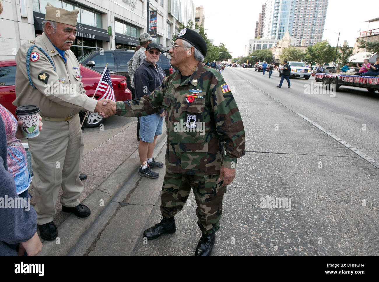 Vietnam männlichen Hispanic Kriegsveteran, grüßt, schüttelt Hände mit Publikum, Kinder während des Veteranen-Day-parade Stockfoto