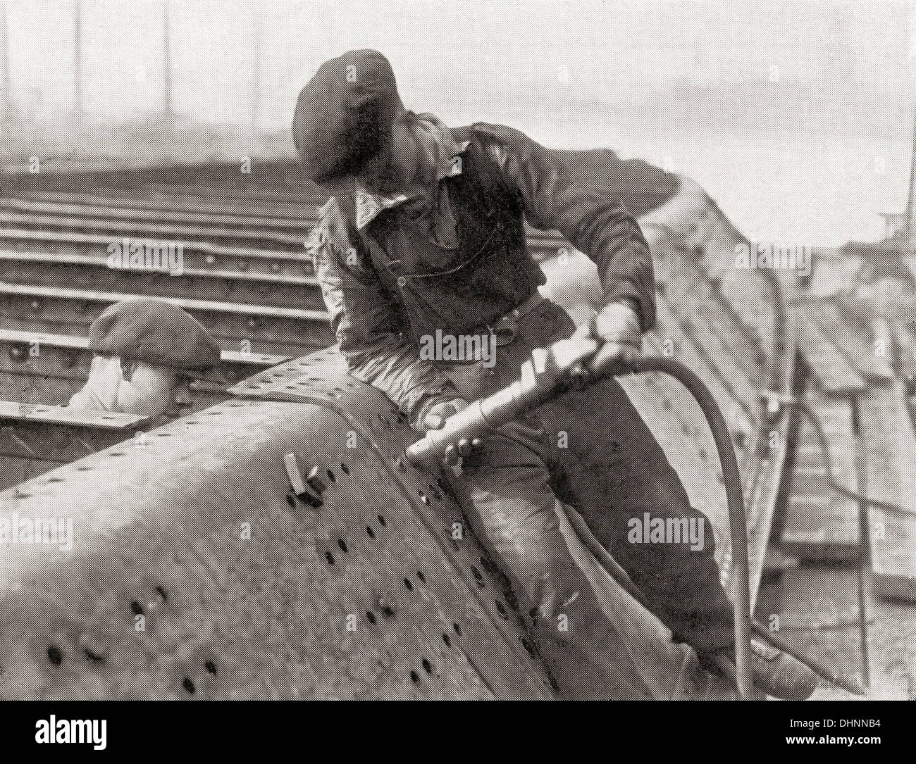 Arbeitnehmer mit einem Hammer des Thor pneumatische Nieten. Von der Romantik des Schiffes Kaufmann veröffentlicht 1931. Stockfoto