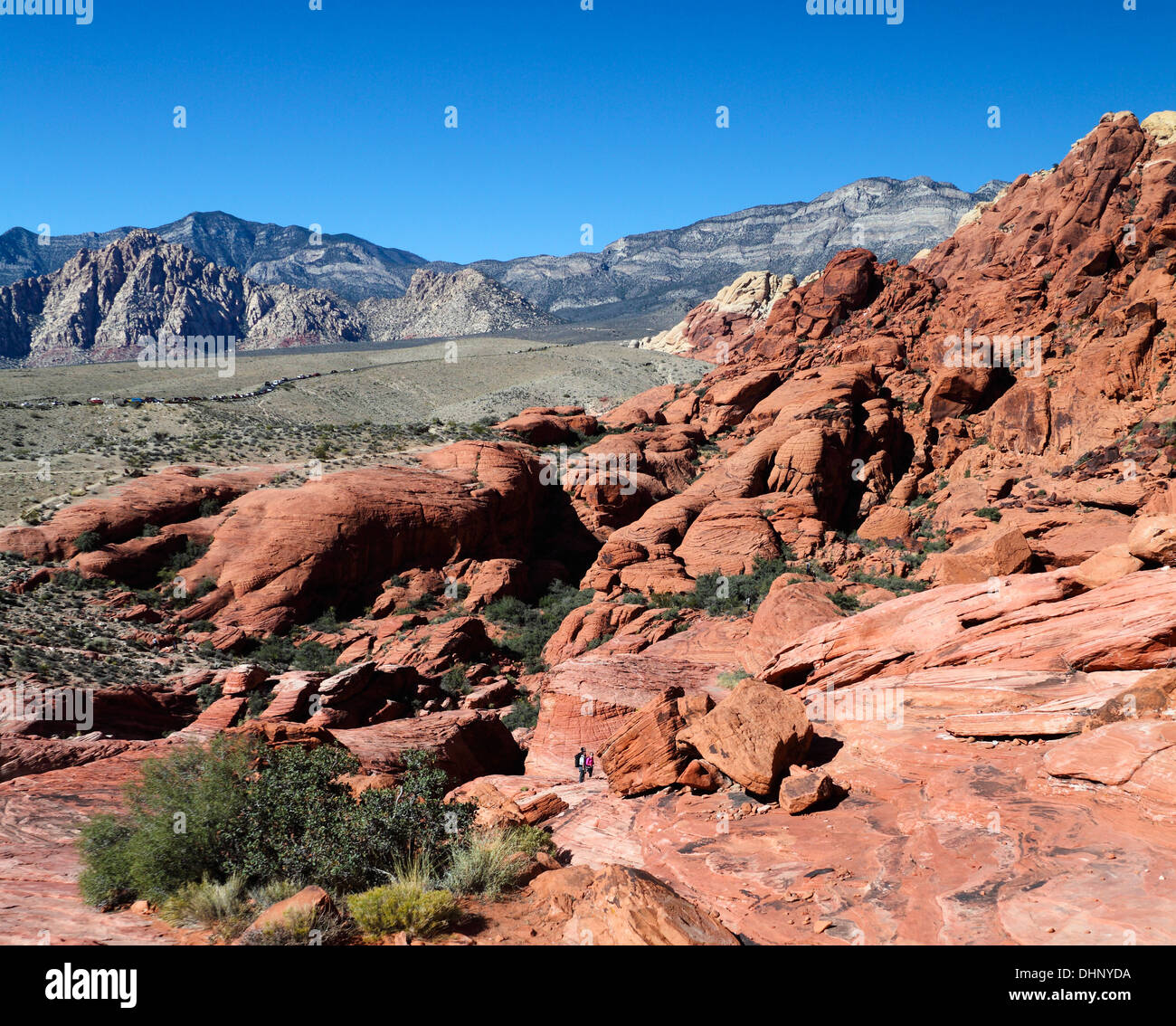 Wanderer und Kletterer erkunden Red Rock Canyon National Conservation Area; die landschaftlich reizvolle Fahrt 13-Meile ist in der Ferne Stockfoto