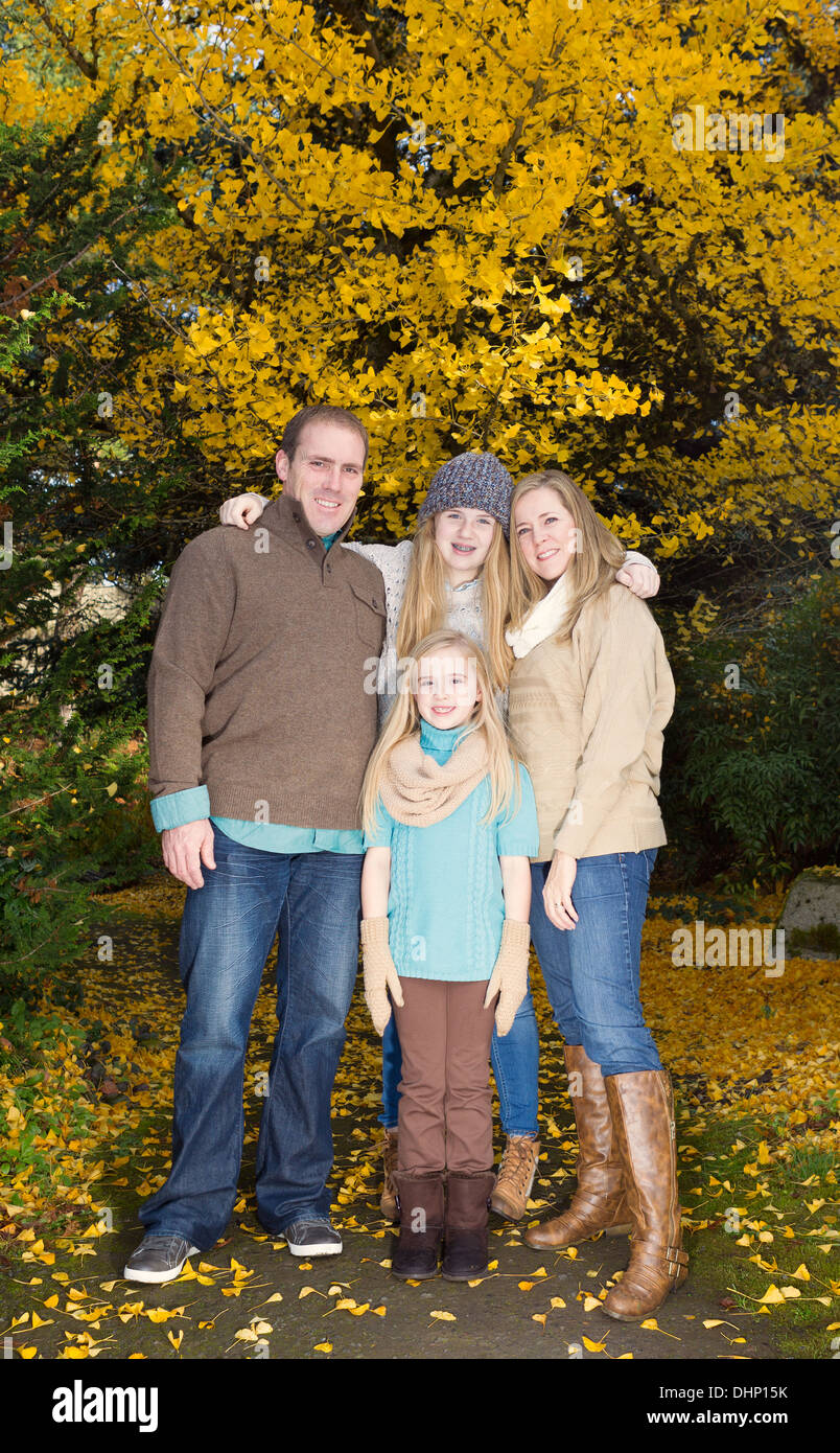 Vertikale Foto der Familie alle halten einander während einer Pause von einem Spaziergang im Park während der Herbstsaison Stockfoto