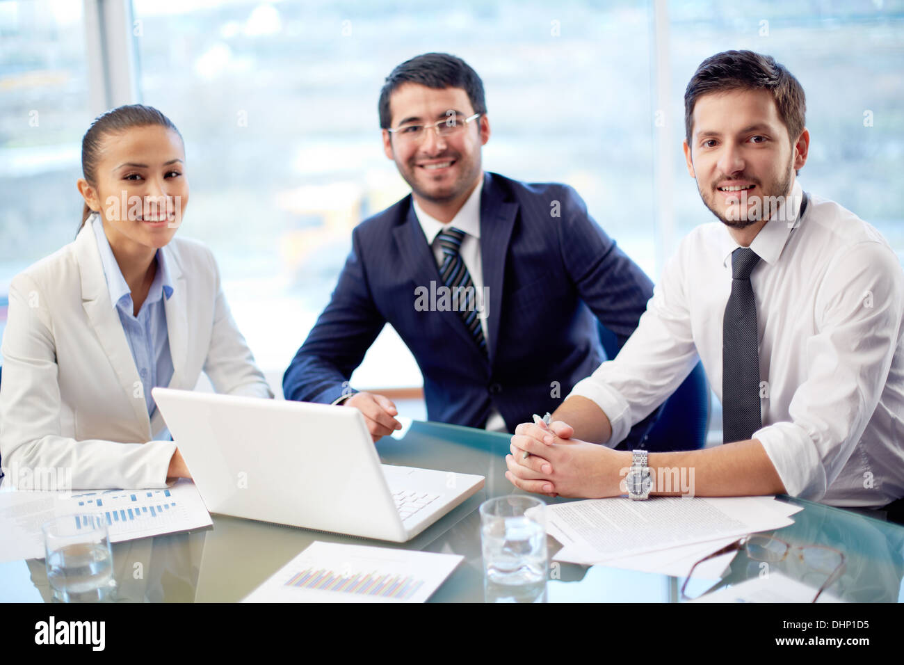Porträt von drei zuversichtlich Kollegen im Büro sitzen Stockfoto
