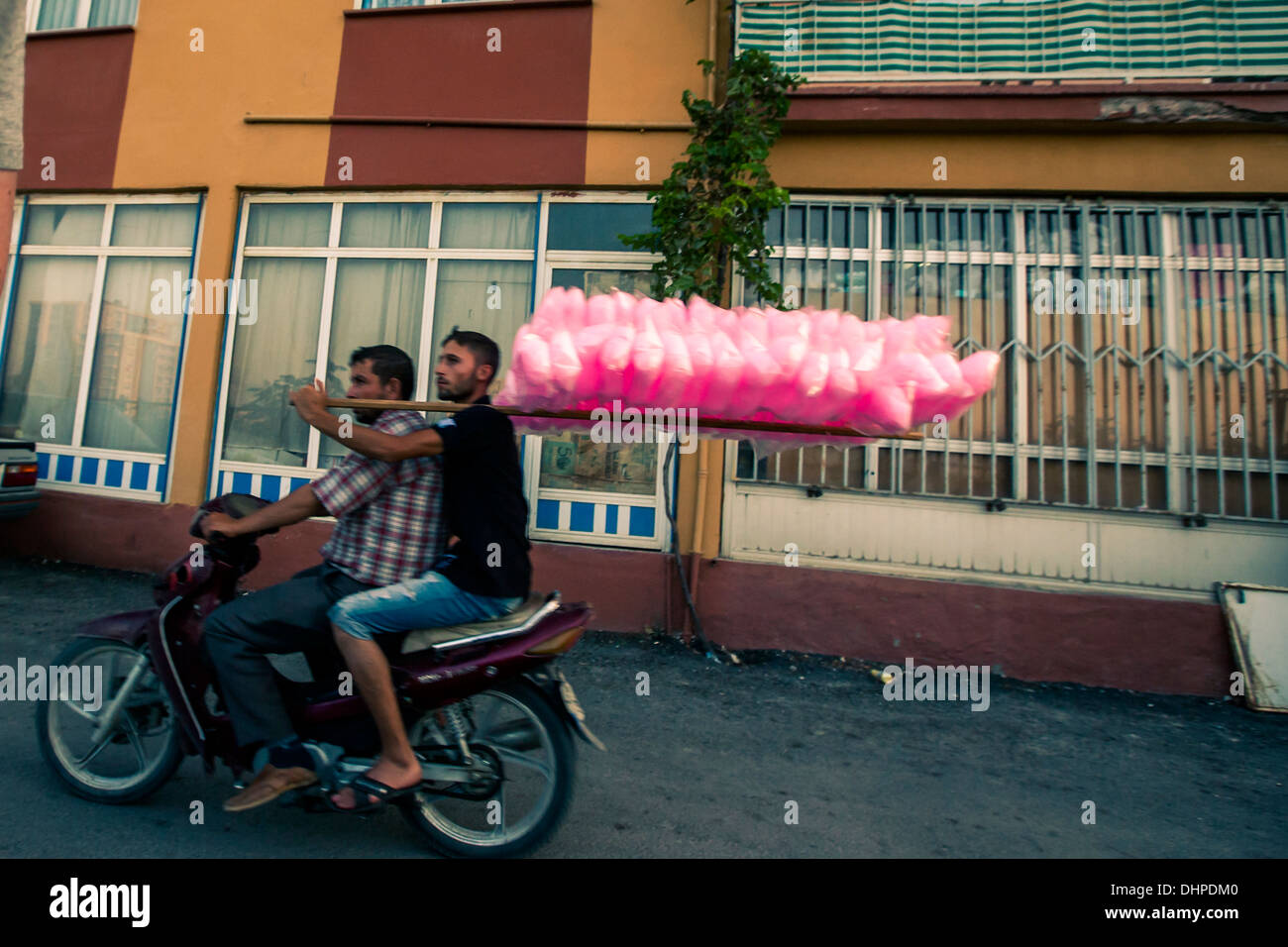 Zwei Mann, ein Motorroller.  Passagier ist Pol mit Zuckerwatte attached to it. hält.  Soma Türkei 2013 Stockfoto