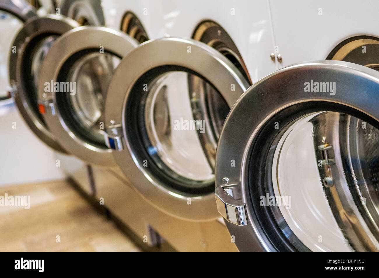 Eine Reihe von Industriewaschmaschinen in einem öffentlichen Waschsalon Stockfoto