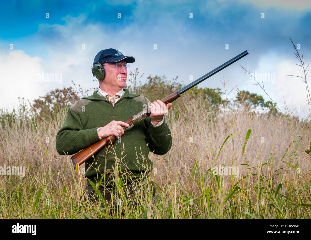 Ein Mann mit einer Schrotflinte Stand wartet auf den Start von einem Fasan-Shooting in England Stockfoto