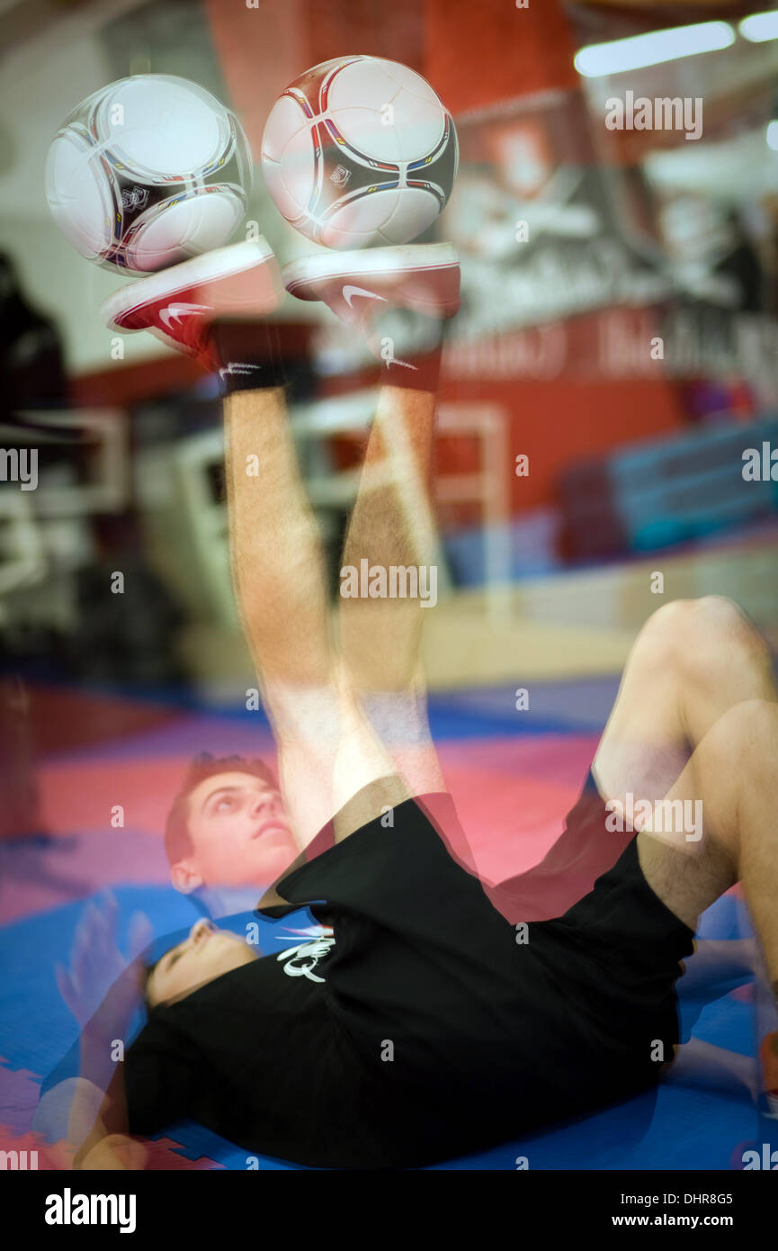 Fußball-Freestyler Marcel Gurk liegt auf dem Rücken und balanciert eine Kugel auf seinen Fuß auf einen neuen Weltrekord auf der 9. Guinness World Records Day in Hamburg, Deutschland, 14. November 2013 festgelegt. Foto: PAULINE WILLRODT Stockfoto