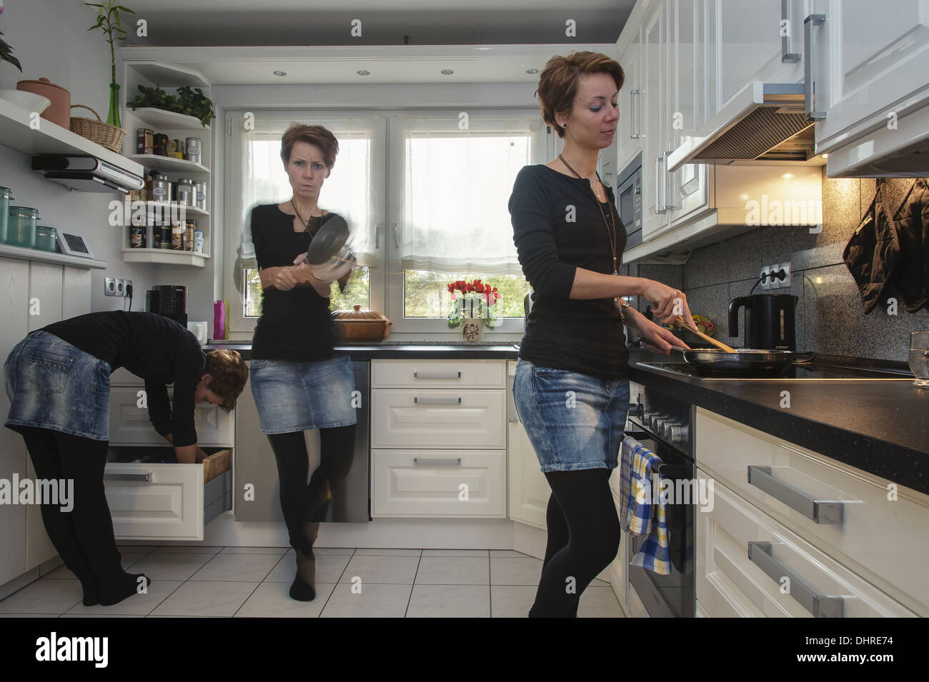 junge Frau in 3 Exemplaren in der Küche Stockfoto