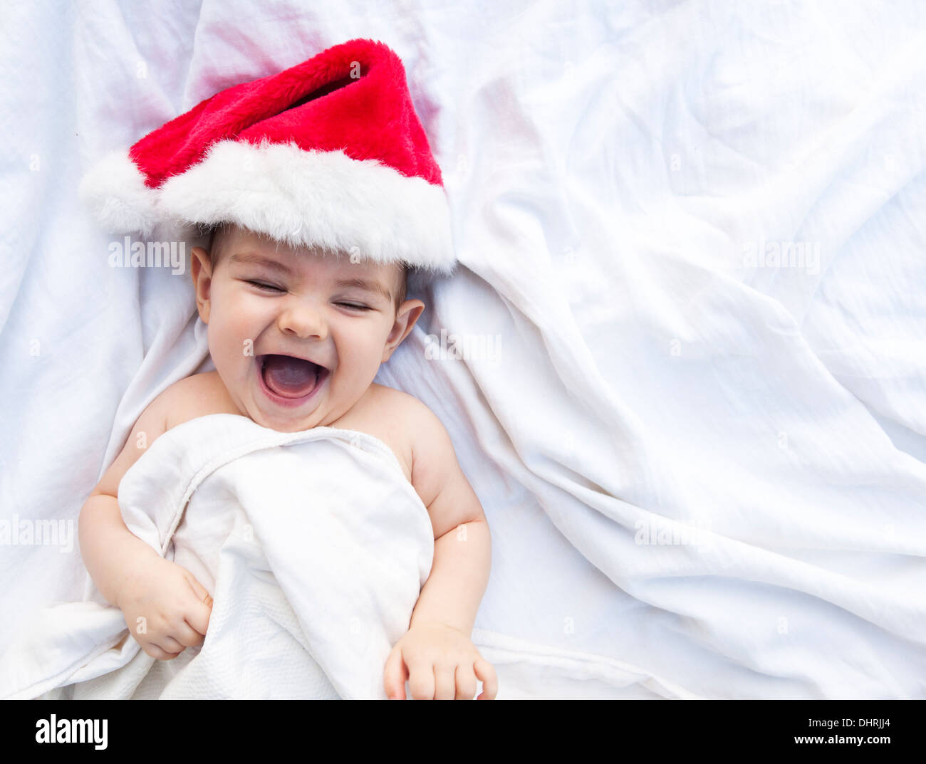 Lachendes Baby in einem Weihnachtsmütze Stockfoto