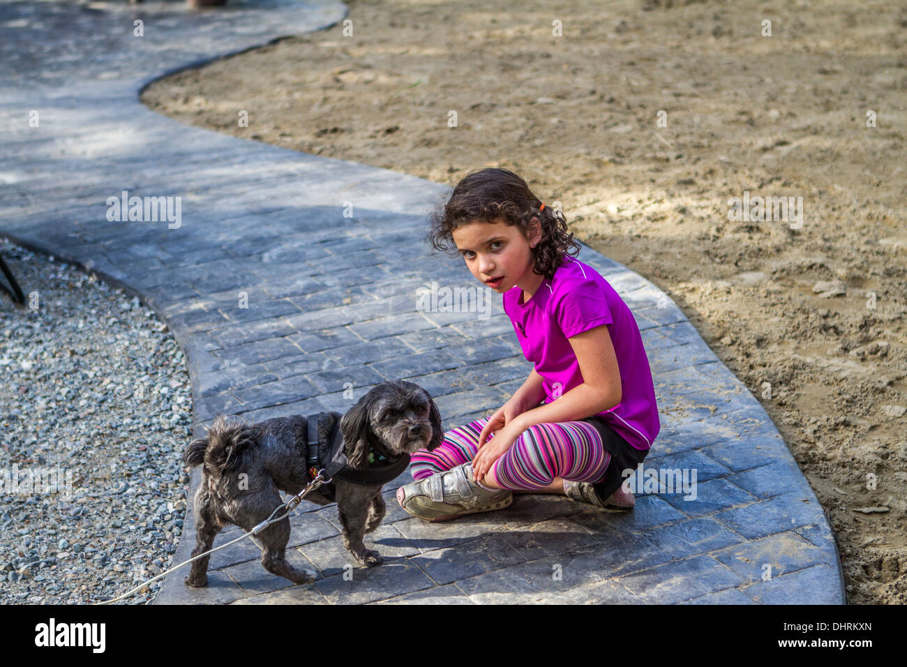 Hübsch, veröffentlichte Modell junges Mädchen, draußen in der Natur, spielen mit ihrem Hund. Stockfoto