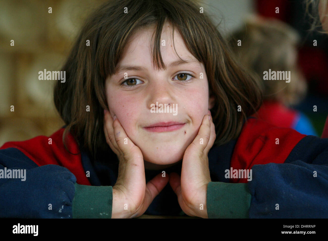 kleines Mädchen mit ihrem Gesicht in ihren Händen Stockfoto