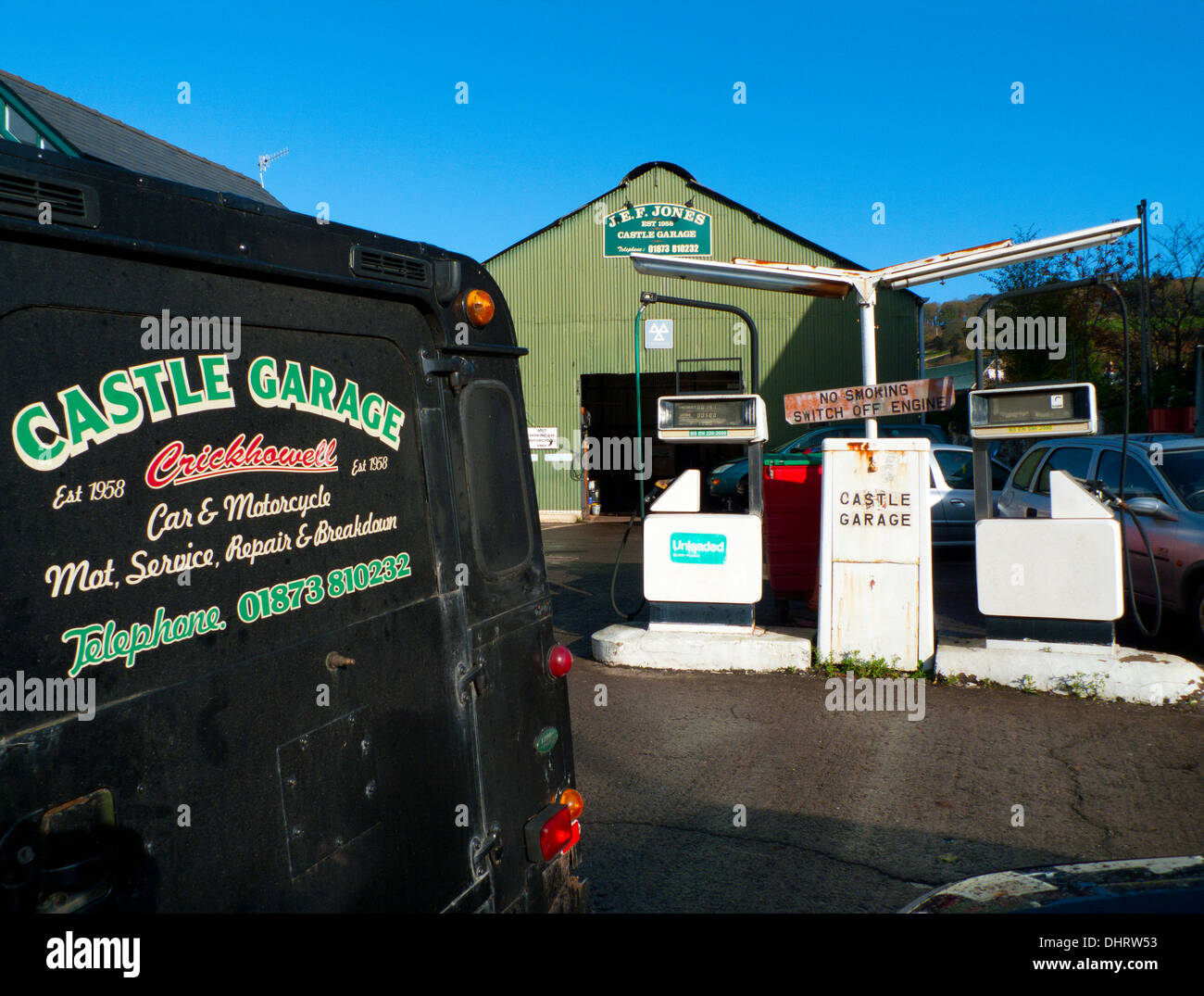 Alte Zapfsäulen, Fahrzeug und Schild in der Schloss-Garage an der A40-Straße durch Crickhowell, Powys, Wales UK KATHY DEWITT Stockfoto