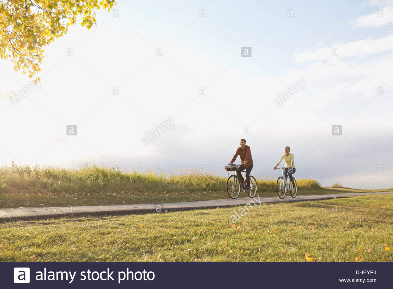 Voller Länge des Paares Radfahren auf Landstraße Stockfoto