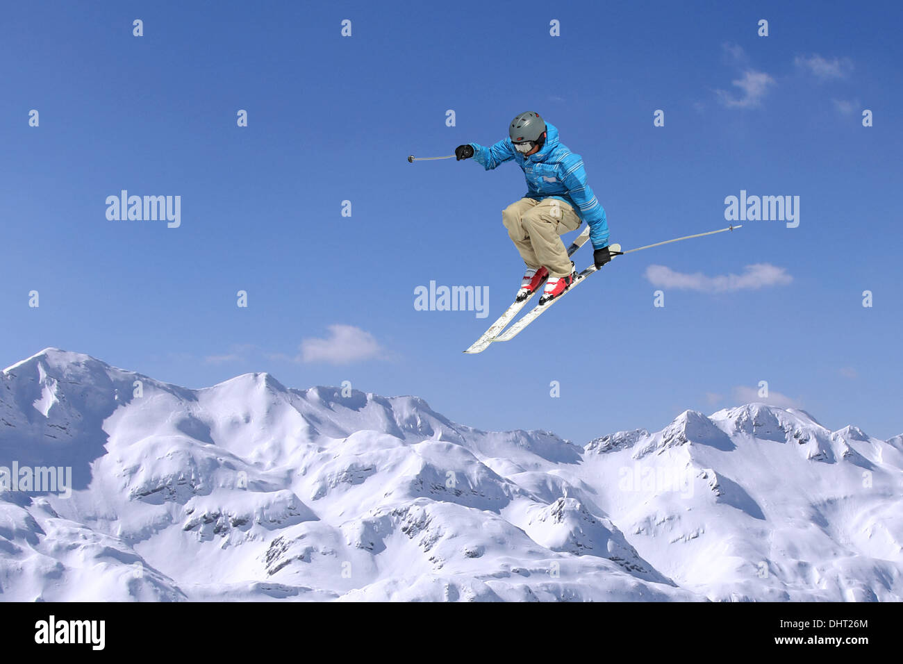 Skifahrer am Sprung im Hochgebirge am sonnigen Tag springen Stockfoto