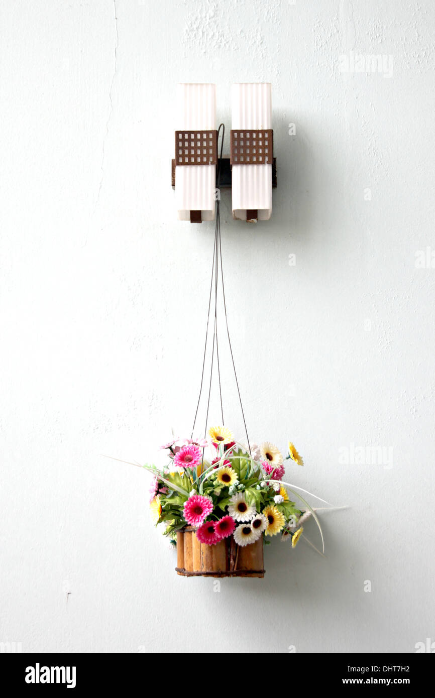 Bunte Blumen in einem hölzernen Korb und es hing. Stockfoto