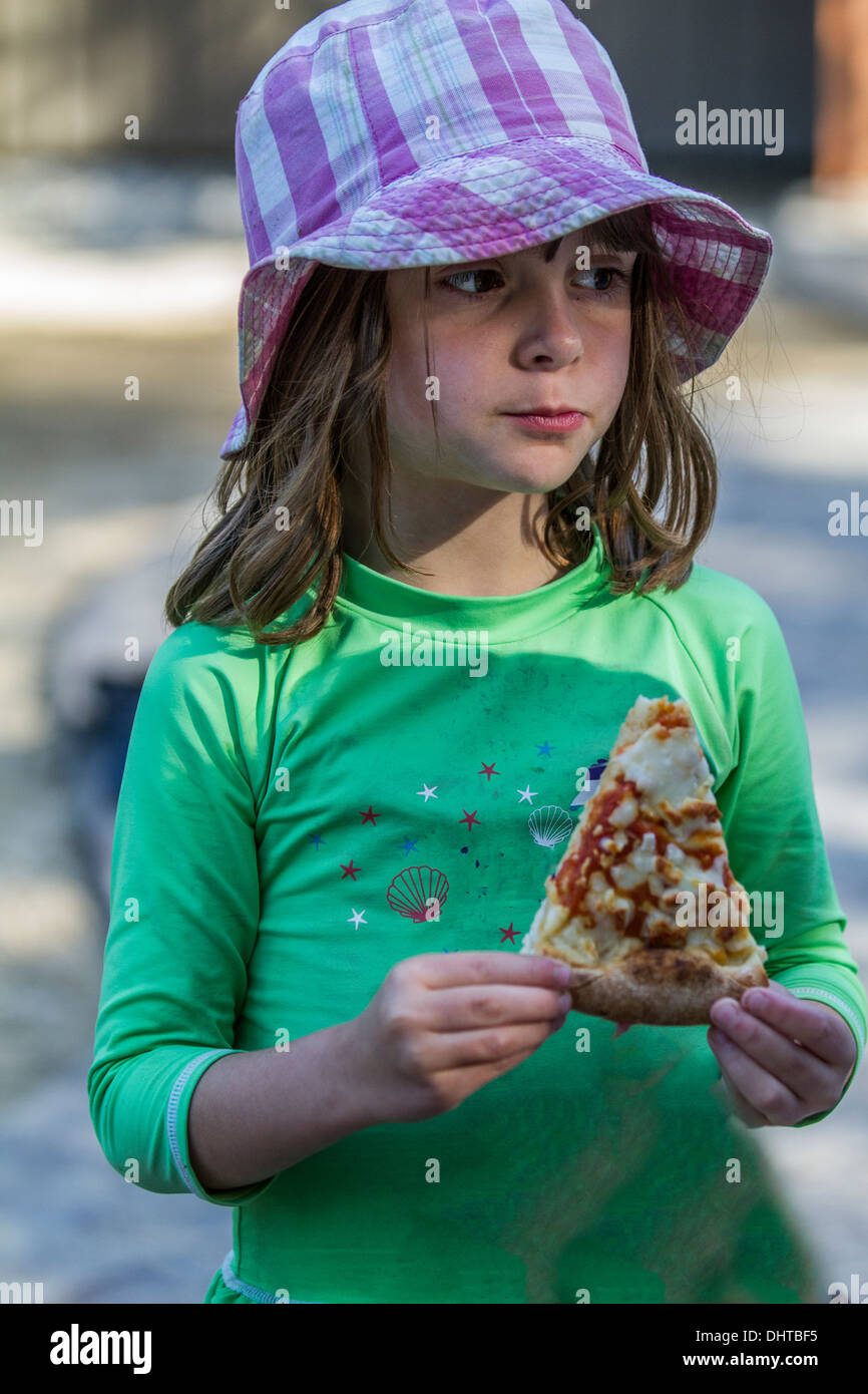 Hübsch, veröffentlichte Modell 4 jährige Mädchen mit Pizza, außerhalb. Stockfoto