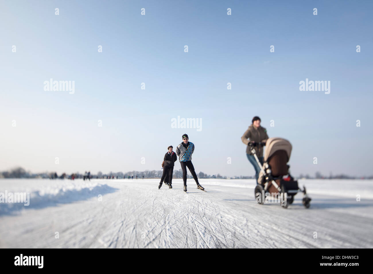 Niederlande, Loosdrecht, Seen genannt Loosdrechtse Plassen. Winter. Eislaufen. Frau mit buggy Stockfoto
