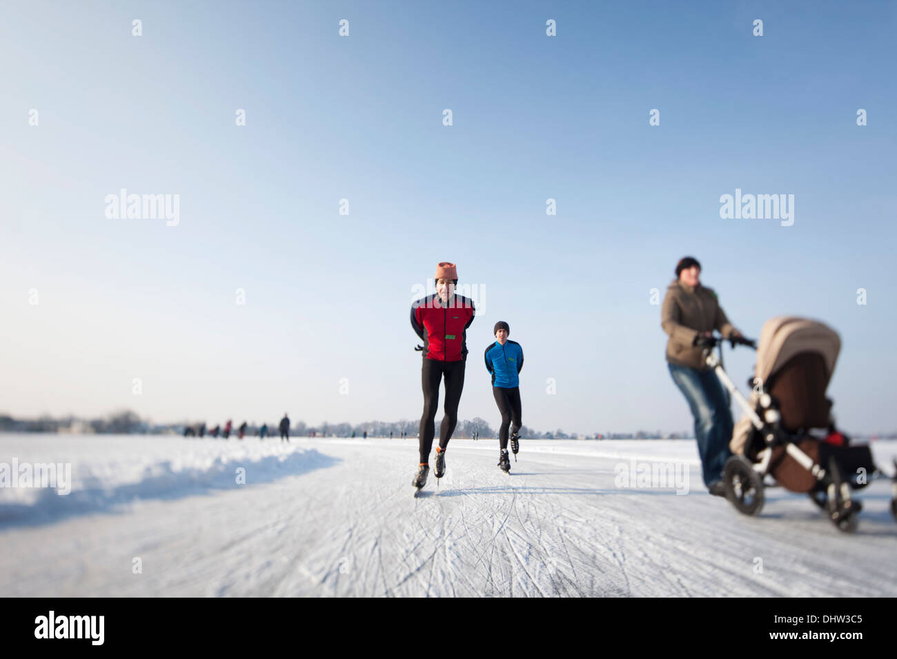 Niederlande, Loosdrecht, Seen genannt Loosdrechtse Plassen. Winter. Eislaufen. Frau mit buggy Stockfoto