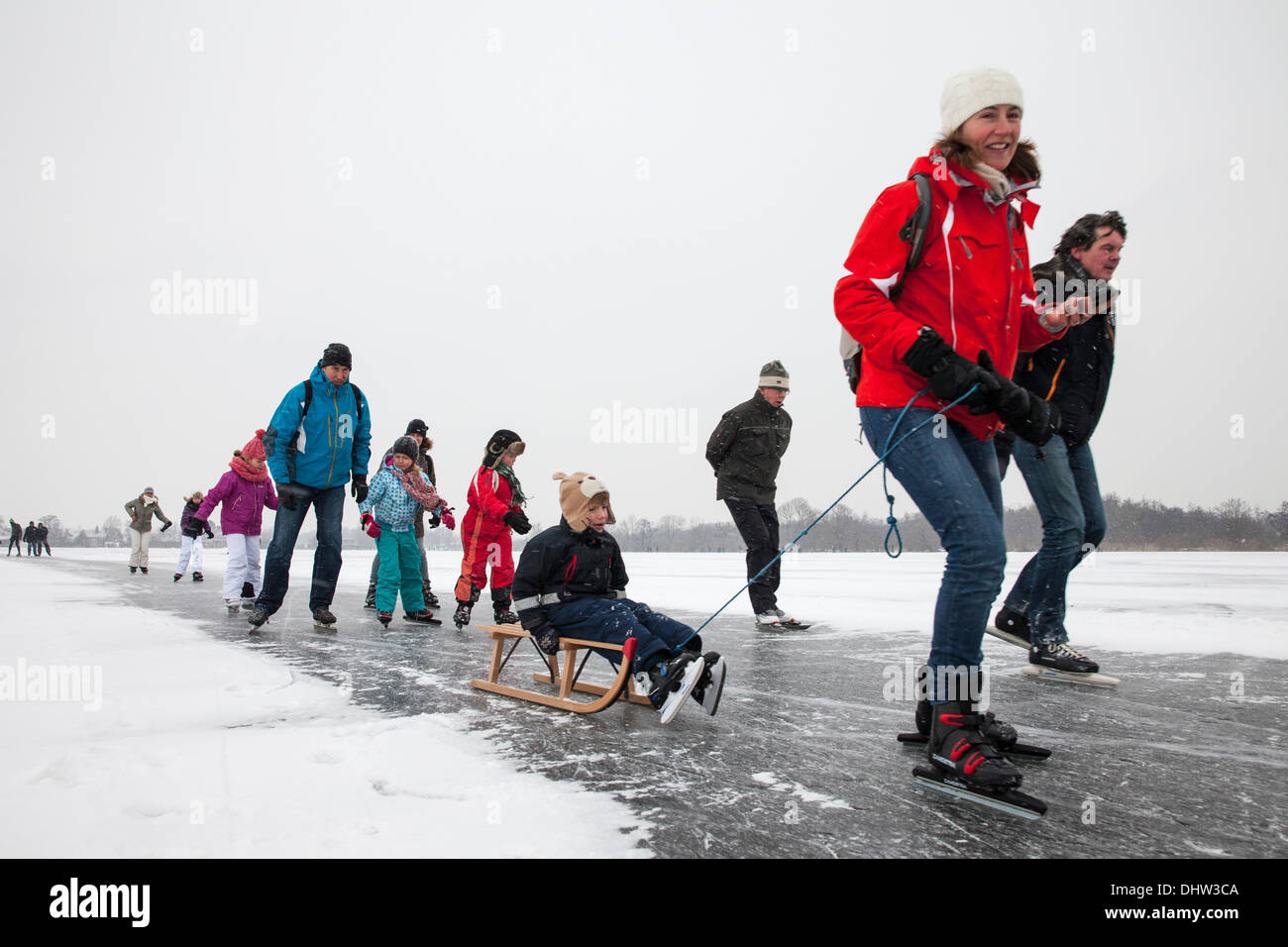 Niederlande, Loosdrecht, Seen genannt Loosdrechtse Plassen. Winter. Familie Eislaufen mit Schlitten Stockfoto