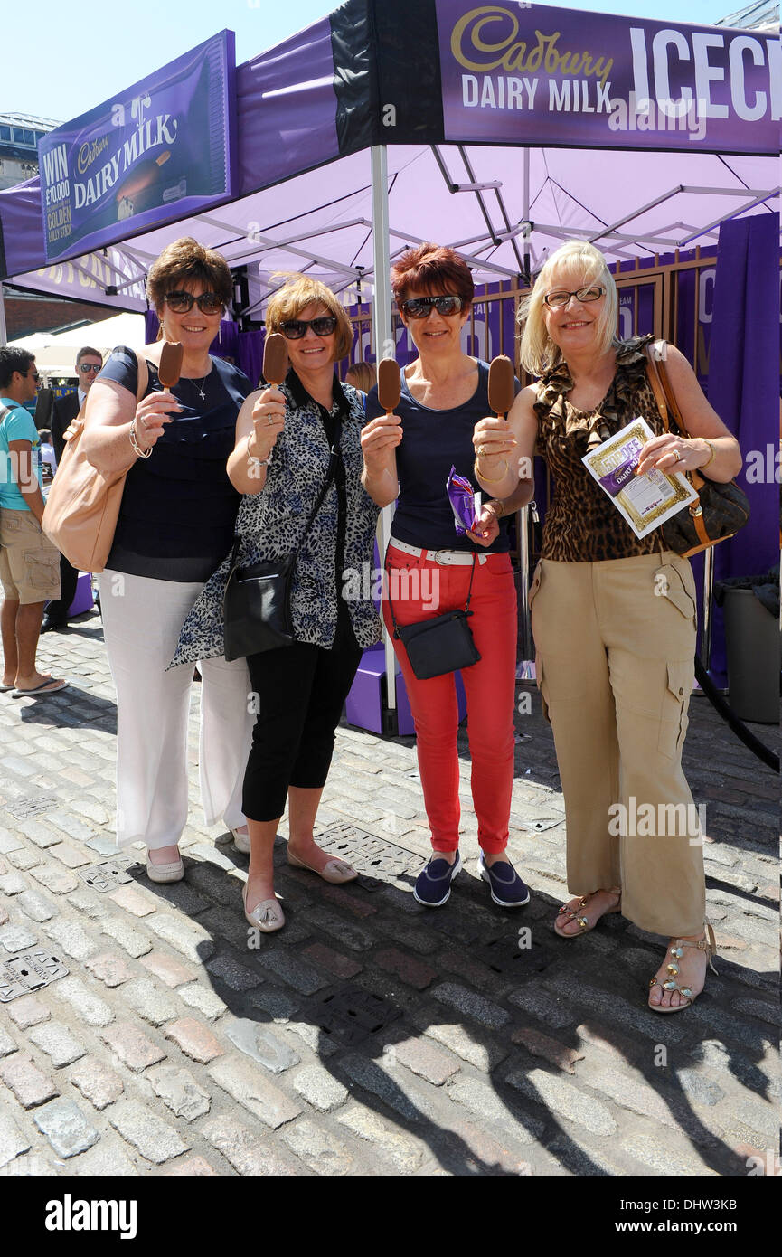 Mitglieder der Öffentlichkeit genießen eine kostenlose Eis, mit freundlicher Genehmigung von Cadbury, in Covent Garden. Zehn glückliche Menschen finden einem goldene Token in ihr Eis welche Entirles Sie an einer Verlosung für £10.000 am Sonntag. London, England - 25.05.12 Stockfoto