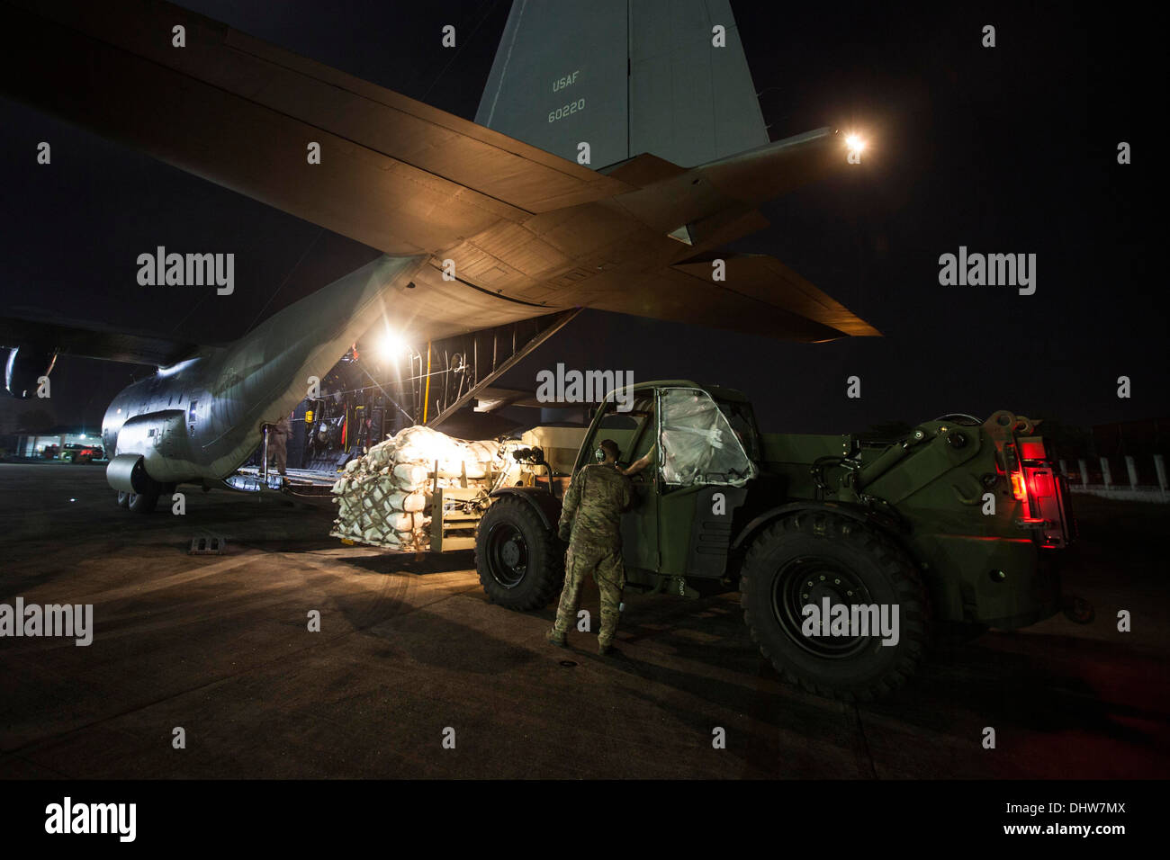 MANILA, Philippinen – US-Marines mit Combat Logistik-Bataillon 4, angebracht zu den 3d Marine Expeditionary Brigade (MEB) laden Sie eine Palette von Lebensmitteln in einer Air Force MC-130 während einer Nacht Lieferung nach Taifun-Hit Tacloban als Teil Betrieb ausgeführt Stockfoto