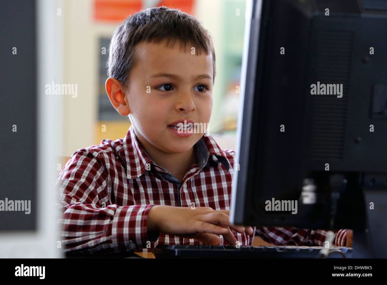 7-jähriger Junge mit einem computer Stockfoto