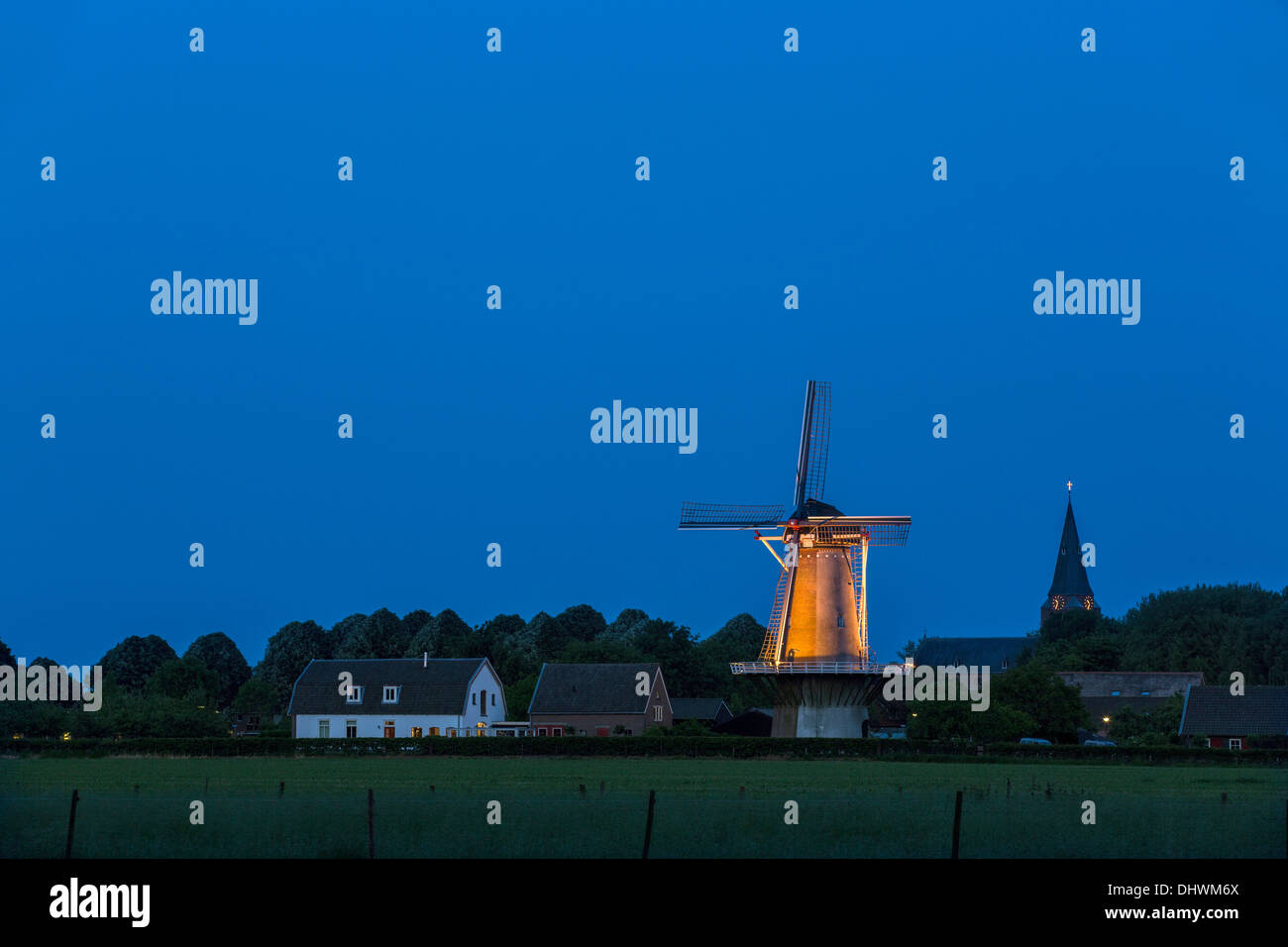 Niederlande, Schalkwijk, Aussicht auf Dorf, Kirche und Windmühle. Dämmerung. Dämmerung Stockfoto