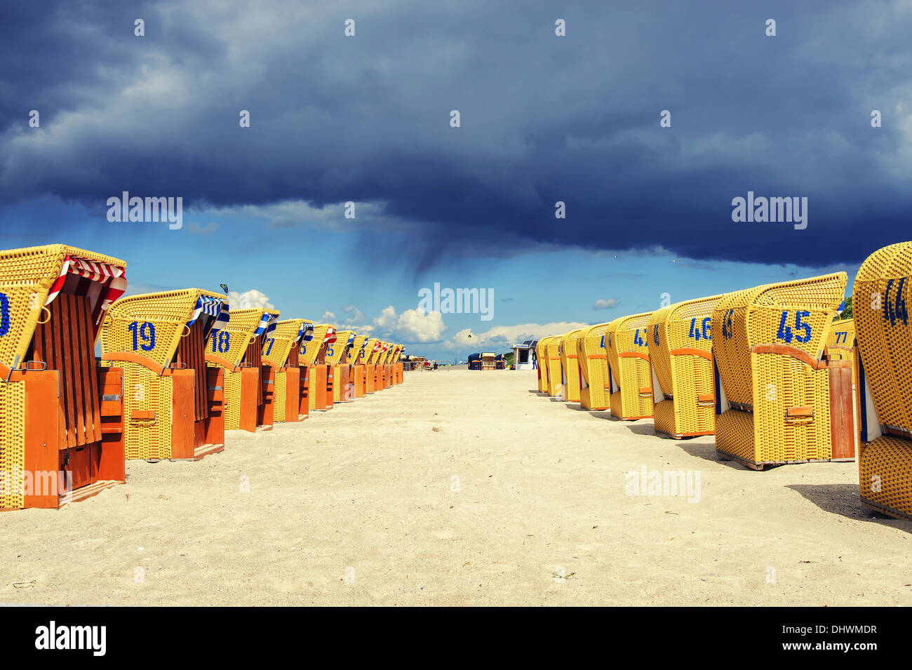 Strandkörbe und dunkle Wolken Stockfoto