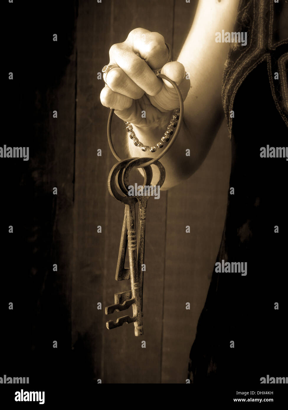 Eine Frau in einem viktorianischen Kleid hält einen Ring von Skelett-Schlüssel. Stockfoto