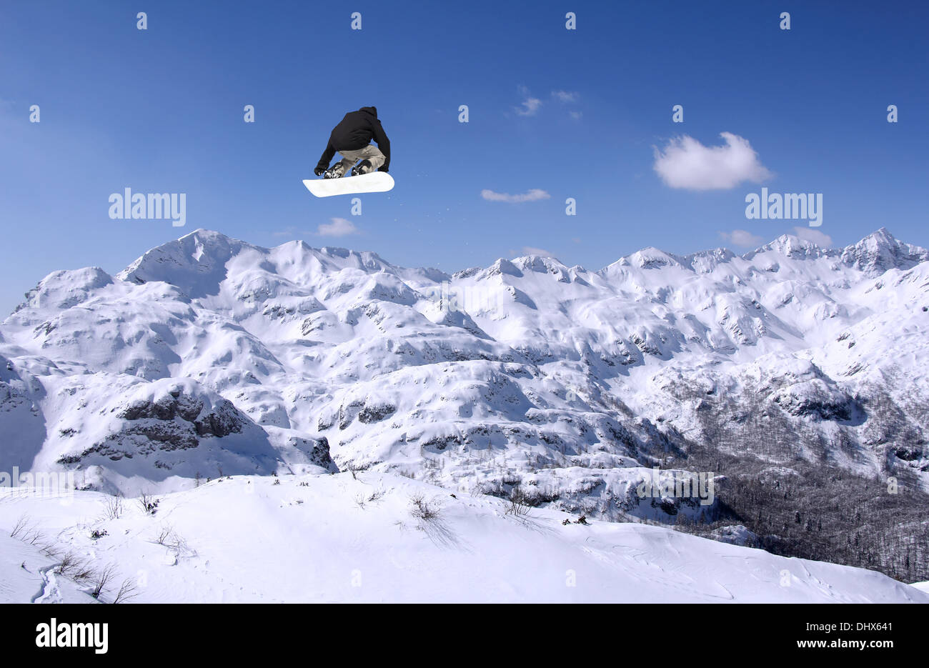 Snowboarder am Sprung im Hochgebirge am sonnigen Tag Stockfoto