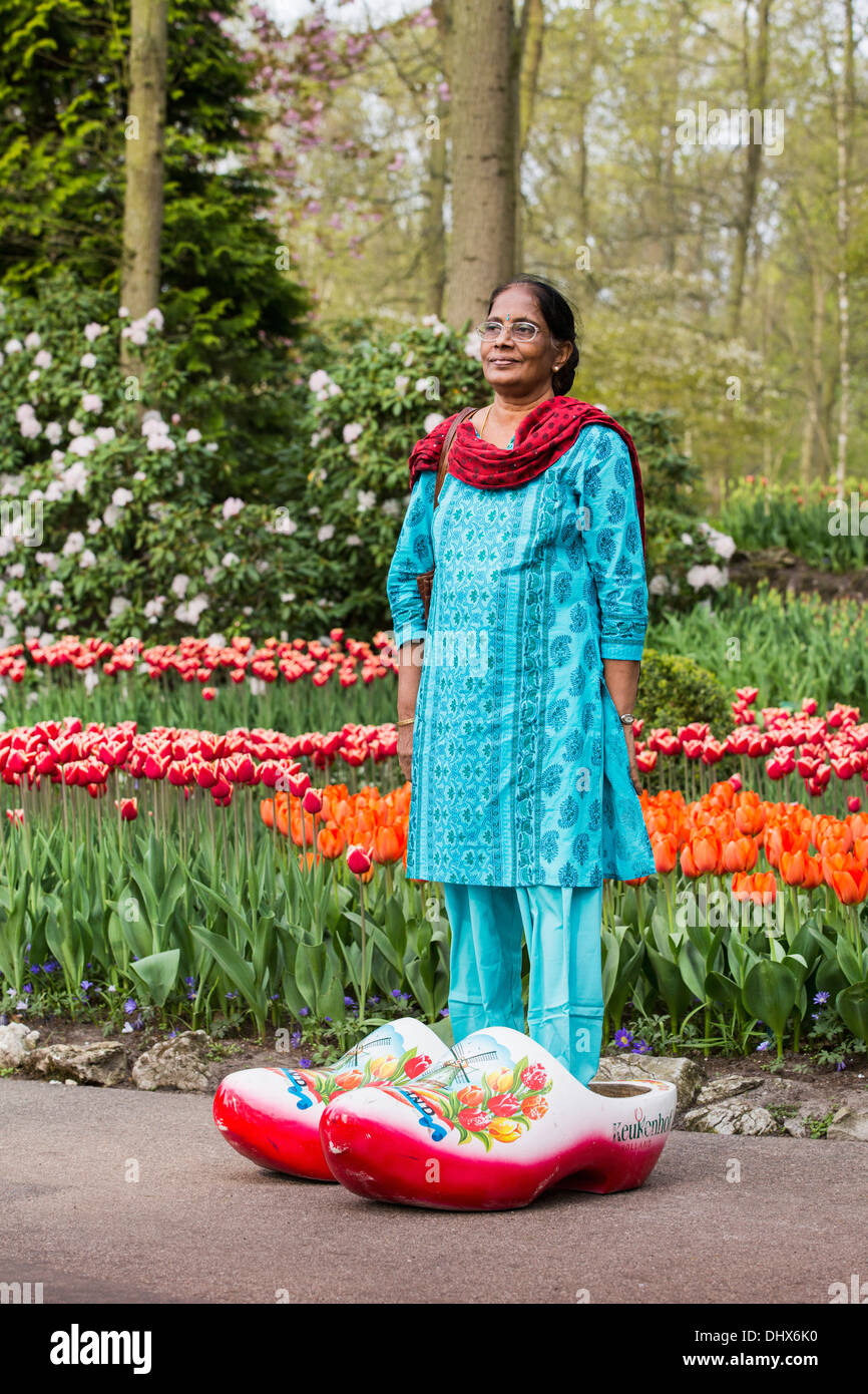 Niederlande, Lisse, Keukenhof Gärten. Indische Frau trägt große Clogs zu fotografieren Stockfoto