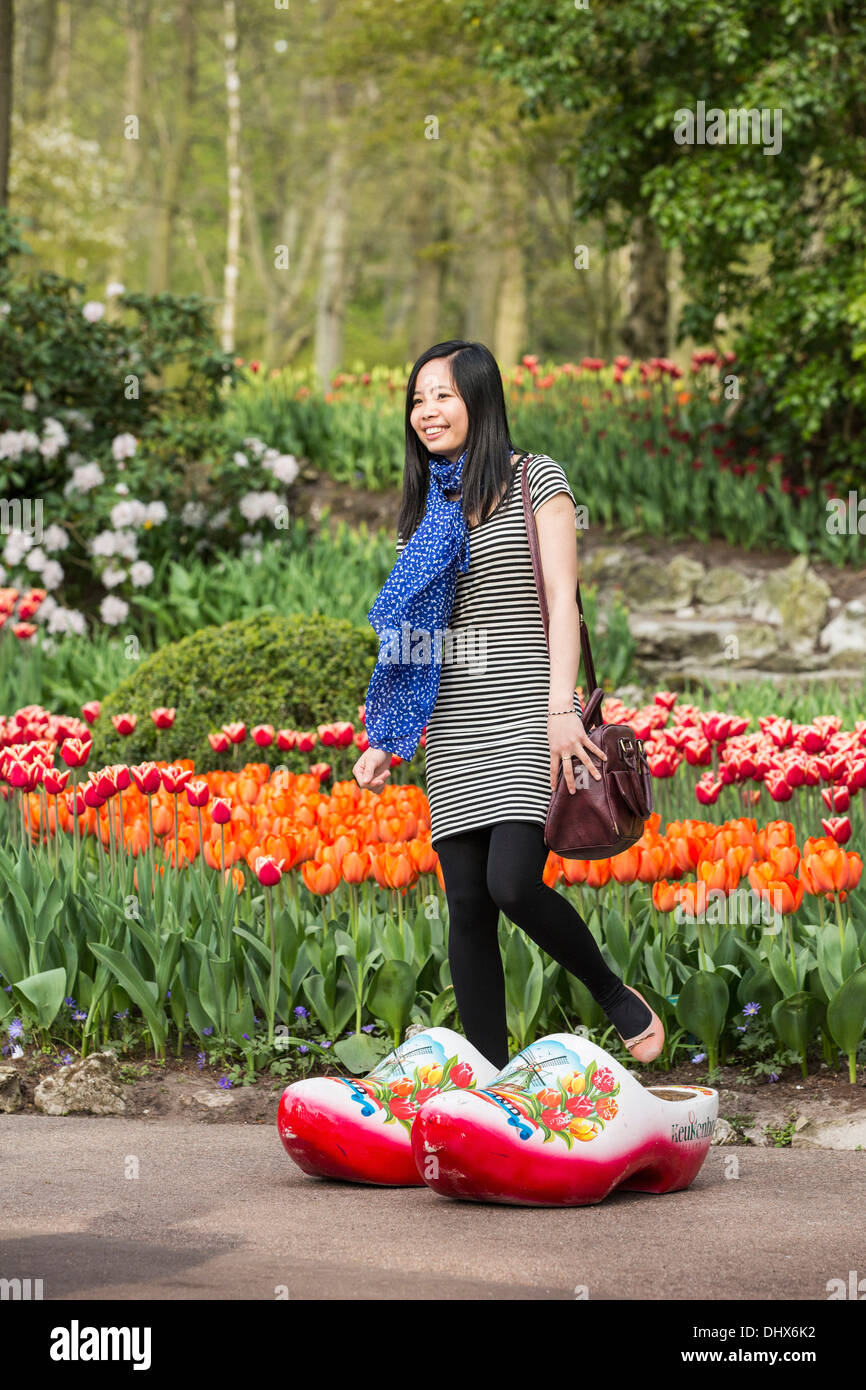 Niederlande, Lisse, Keukenhof Gärten. Asiatische Frau tragen große Clogs zu fotografieren Stockfoto