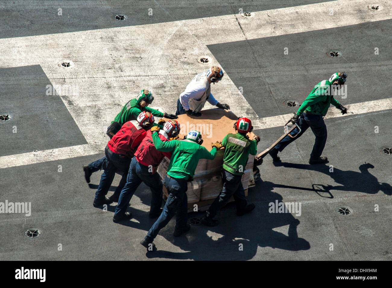 Matrosen an Bord der USS George Washington bewegen Behälter mit frischem Wasser auf Hubschraubern für Lieferung an Land zur Unterstützung der Taifun Haiyan Hilfsmaßnahmen 15. November 2013 werden Offshore-Tacloban, Philippinen. Stockfoto