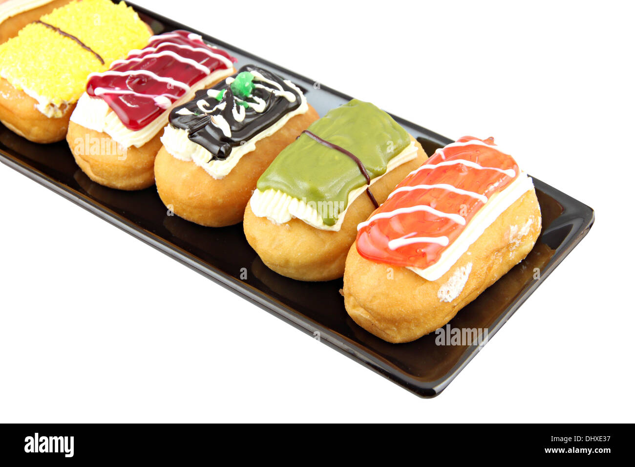 Donuts sortieren in der schwarzen Schale auf weißem Hintergrund. Stockfoto