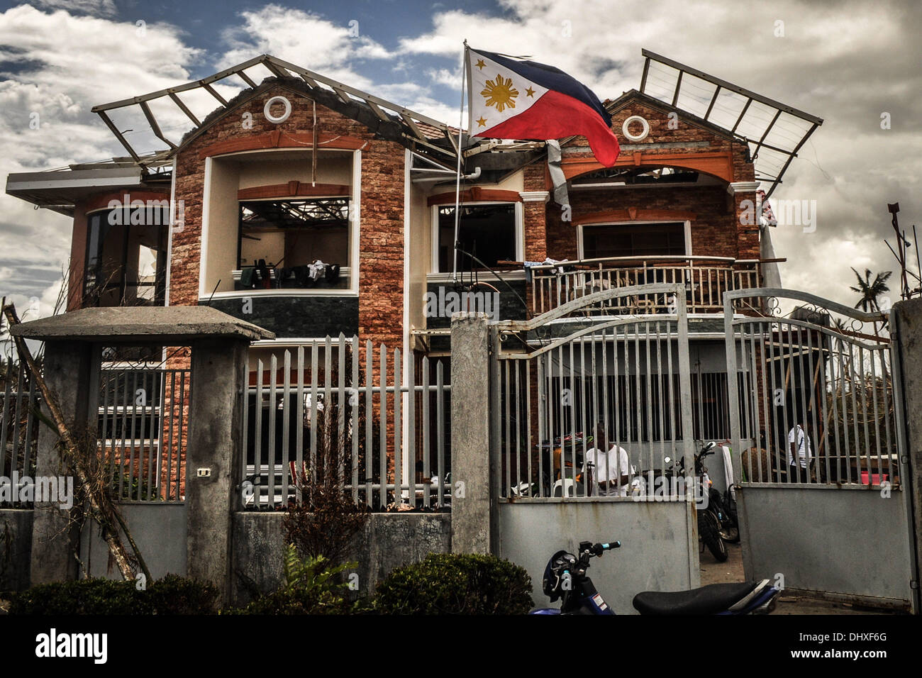 LEYTE, Philippinen. 14. November 2013. Die philippinische Flagge Wellen vor einem zerstörten Haus in der Provinz Leyte am 14. November 2013. Super Taifun Haiyan, lokal bekannt als '' Yolanda'', die weltweit stärkste Taifun pummeled durch central Visayas am 09. November verlassen enormen Verwüstungen in der Region. : Bildnachweis George Calvelo/NurPhoto: George Calvelo/NurPhoto/ZUMAPRESS.com/Alamy Live-Nachrichten Stockfoto