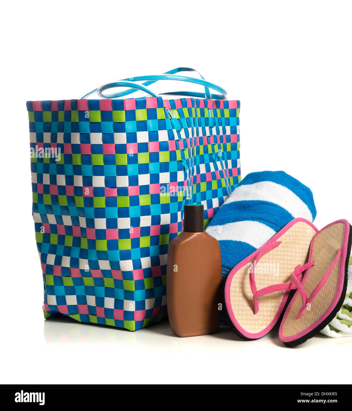 Eine Badetasche mit einem gestreiften Handtuch, Sonnencreme und rosa Flip-flops auf weißem Hintergrund Stockfoto