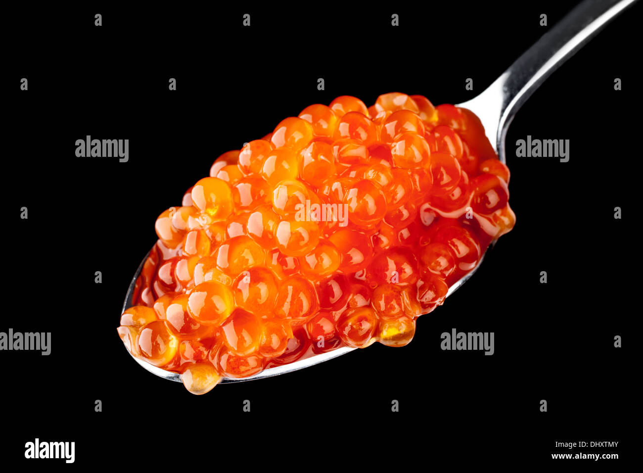 Roter Kaviar in Metall Teelöffel auf schwarzem Hintergrund isoliert Stockfoto