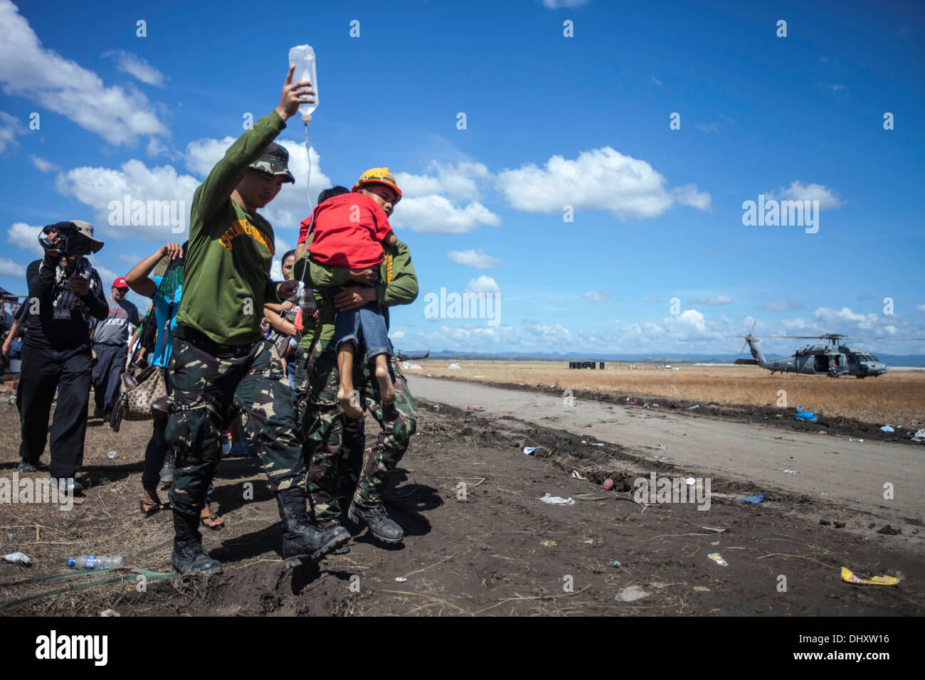 Ein Filipino junge mit einer Infusion wird durch Soldaten der philippinischen Armee unterstützt, da er in ein Luftfahrzeug für tr getragen wird Stockfoto