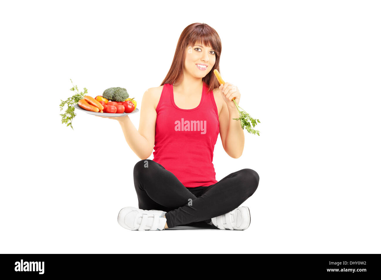 Junge schöne Frau in einem Stockwerk Halteplatte mit Gemüse und Karotten Stockfoto