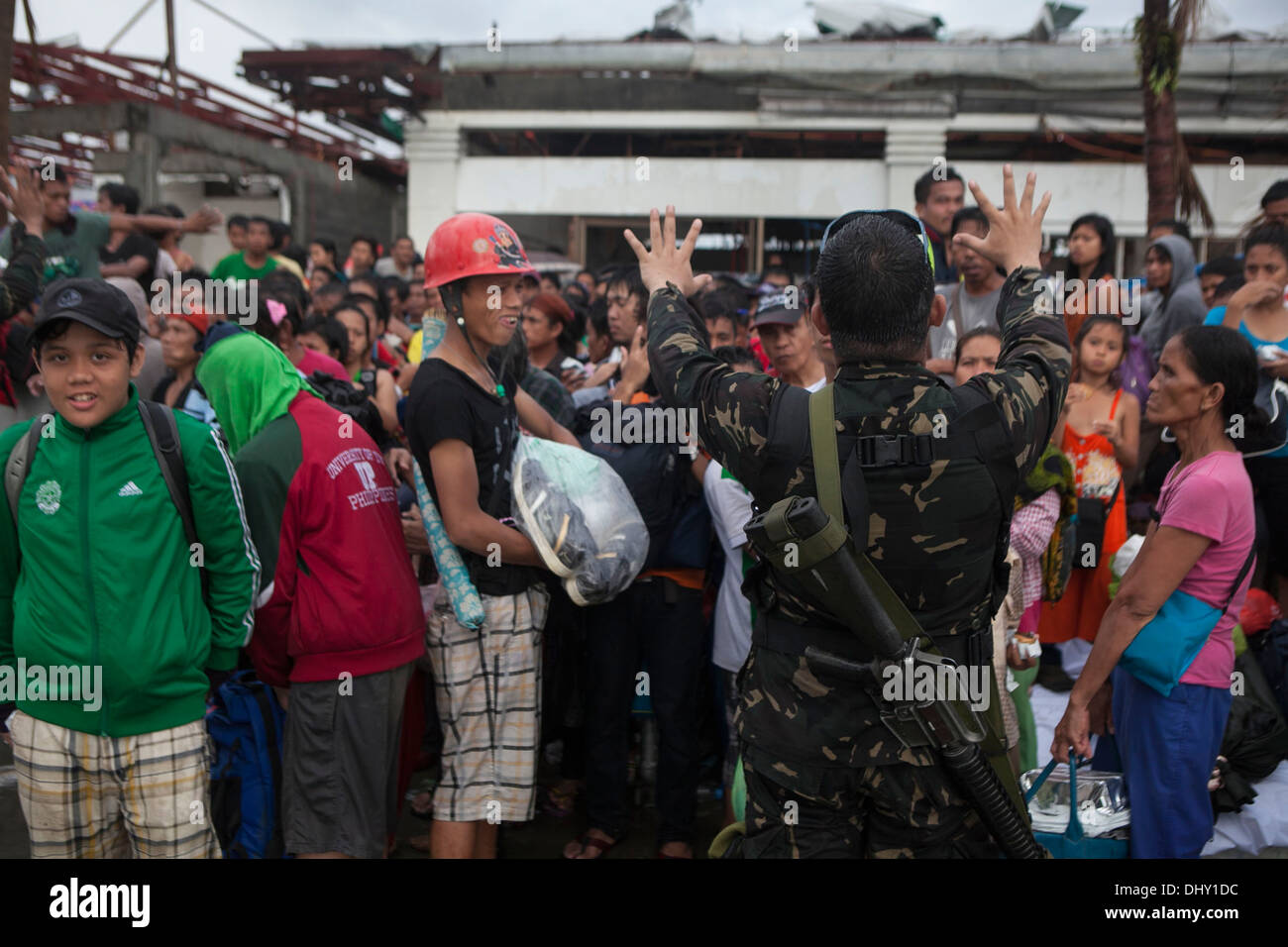 LEYTE, Republik der Philippinen – eine bewaffnete Kräfte der Philippinen Soldat gibt Anweisungen zu einer Masse auf Tacloban Air Base 14 November im Rahmen der Operation Damayan. Die Regierung der Philippinen ist eng mit internationalen Hilfsaktionen e Koordination Stockfoto