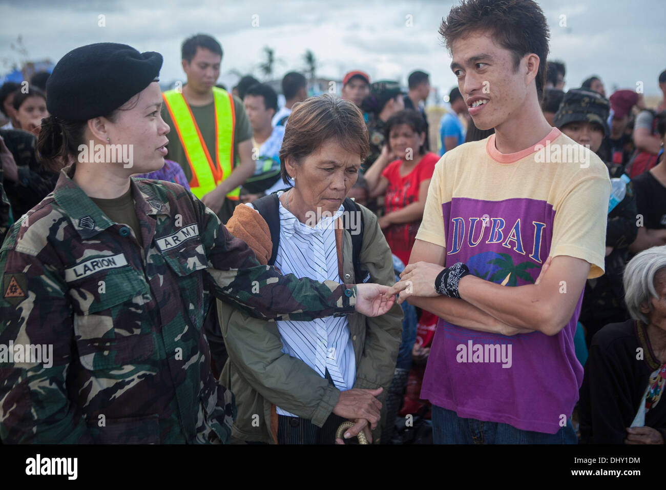 LEYTE, spricht Republik der Philippinen – eine bewaffnete Kräfte der Philippinen Soldat für die Zivilbevölkerung, während sie darauf warten, von Tacloban Air Base im Rahmen der Operation Damayan 14 November geflogen werden. Die Regierung der Philippinen ist mit in enger Abstimmung. Stockfoto