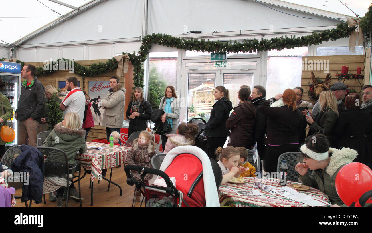 Woburn Sands, Milton Keynes, Bucks, UK. 16. November 2013. Santa Claus kamen in Stil, begleitet von seinen Elfen und die Besetzung von Milton Keynes Theatre Pantomime zu Beginn der Weihnachtszeit bei Frost Gartencenter einläuten, Woburn Sands Hunderte von aufgeregten Kinder gesäumten Allee ins Zentrum nach Santa an seine Weihnachten Grotte später erfüllen. Die Eisbahn und angrenzenden "Hungrig Moose" Café auch geöffnet für Geschäft heute, da die festliche Saison 2013 bei Frost gut war und wirklich offen deklariert.  Foto von Keith Mayhew / Alamy Live News Stockfoto