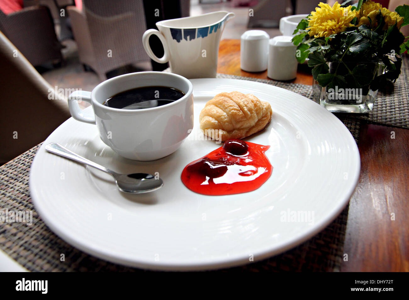 Kaffee, Brot und Marmelade auf einem weißen Teller. Stockfoto