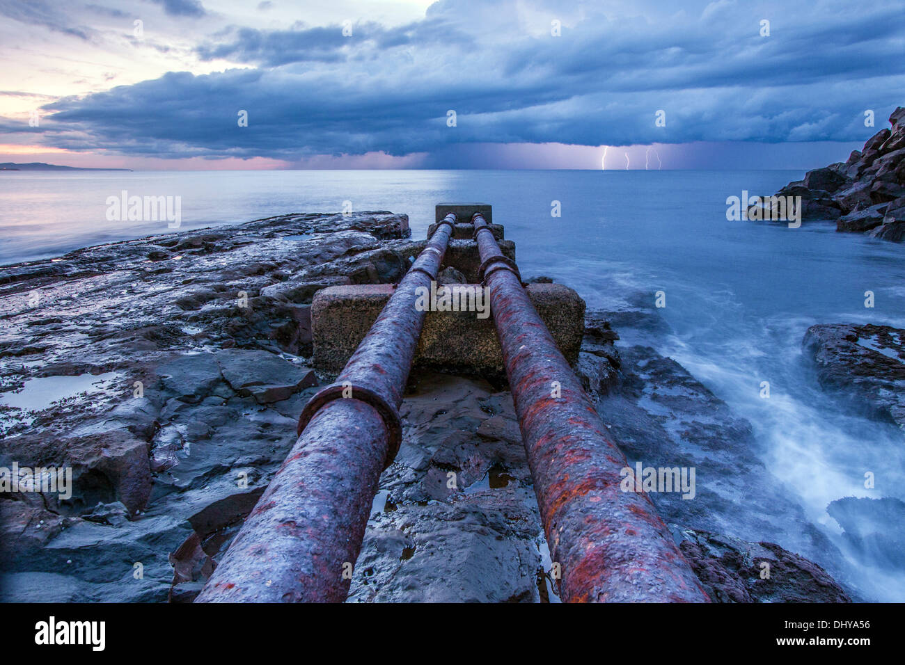 Rohre in den Ozean mit Beleuchtung im Hintergrund Stockfoto